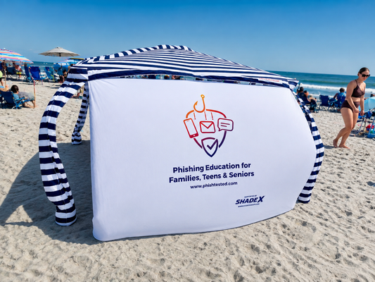 Custom-printed PhishTested logo on a ShadeX side wall clipped to a CoolCabana at the beach